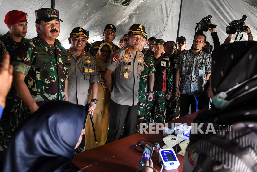 Panglima TNI Marsekal TNI Hadi Tjahjanto (kiri) bersama Kapolri Jenderal Pol Idham Azis (ketiga kiri) melakukan kunjungan ke Posko Bakti Kesehatan di Ranai, Natuna, Kepulauan Riau, Kamis (13/2/2020). 