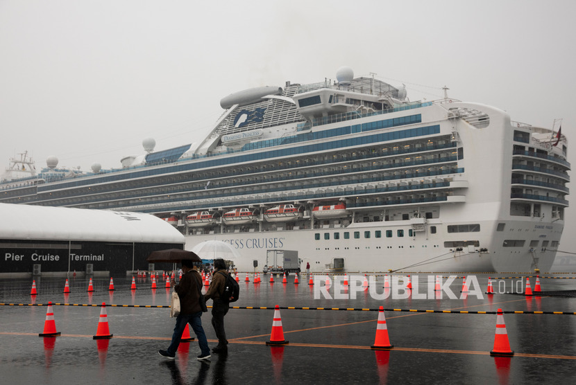 Pengunjung berjalan melewati kapal pesiar Diamond Princess yang dikarantina di Yokohama. Sebanyak 14 warga AS yang positif Corona tetap ikut pulang ke AS dari kapal pesiar Diamond Princess.