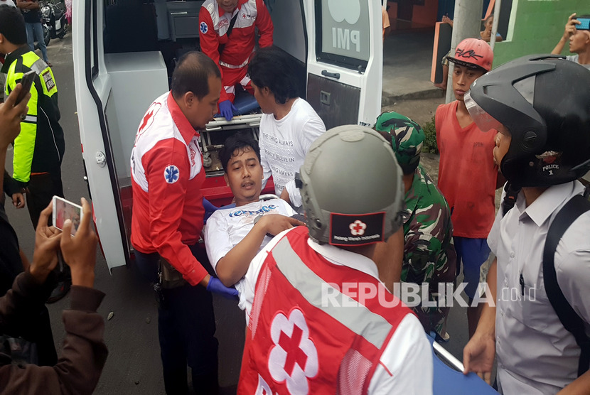 Petugas mengevakuasi korban luka pascakerusuhan yang diduga akibat ulah suporter saat laga semi final Piala Gubernur Jawa Timur antara Persebaya melawan Arena FC di Blitar, Jawa Timur, Selasa (14/2/2020).