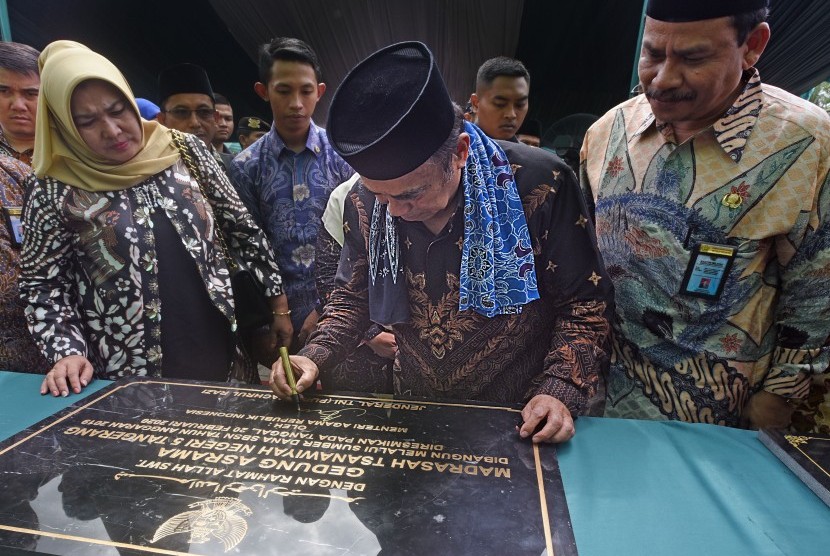 Menteri Agama Fachrul Razi (tengah) didampingi Kakanwil Kemenag Banten Bazari Syam (kanan) dan staf menandatangani prasasti saat peresmian sejumlah bangunan sekolah madrasah di Serang, Banten, Kamis (20/2/2020). 