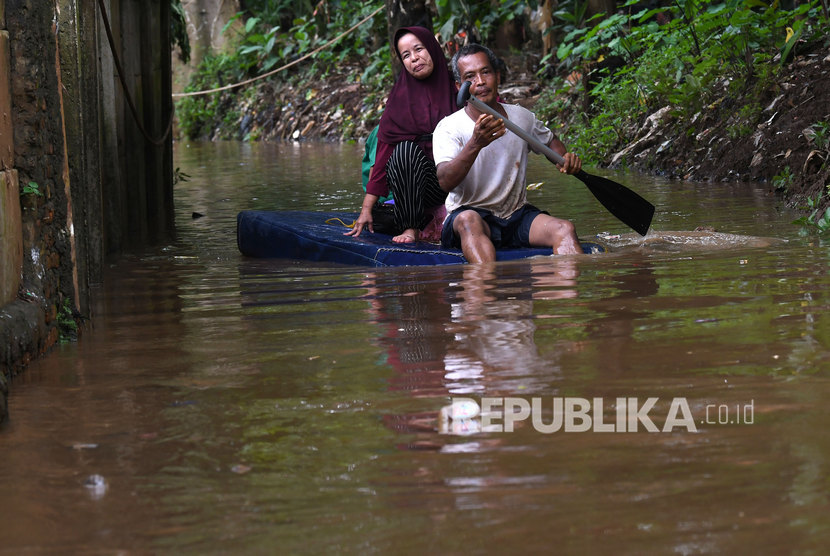 Warga menggunakan perahu buatannya untuk menyusuri jalan perkampungan yang tergenang banjir luapan air Sungai Ciliwung di Cawang, Jakarta, Kamis (20/2/2020).