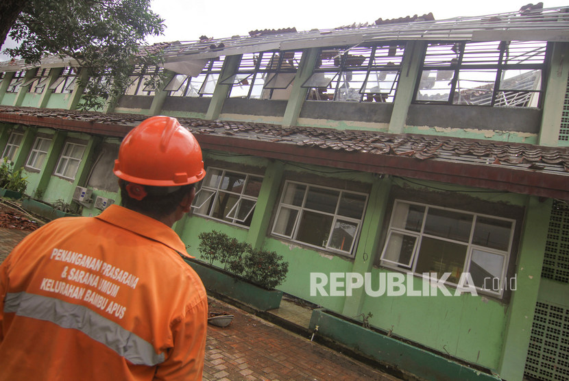 Petugas melihat kondisi ruang kelas yang ambruk di SMKN 24 Bambu Apus, Jakarta Timur, Jumat (21/2/2020).