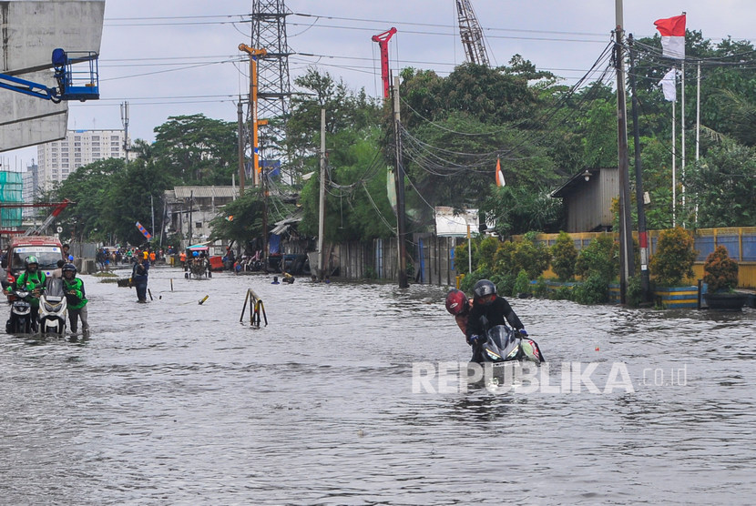 Sejumlah pengendara motor menerobos banjir di Pulogadung, Jakarta Timur, Minggu (23/2/2020). 