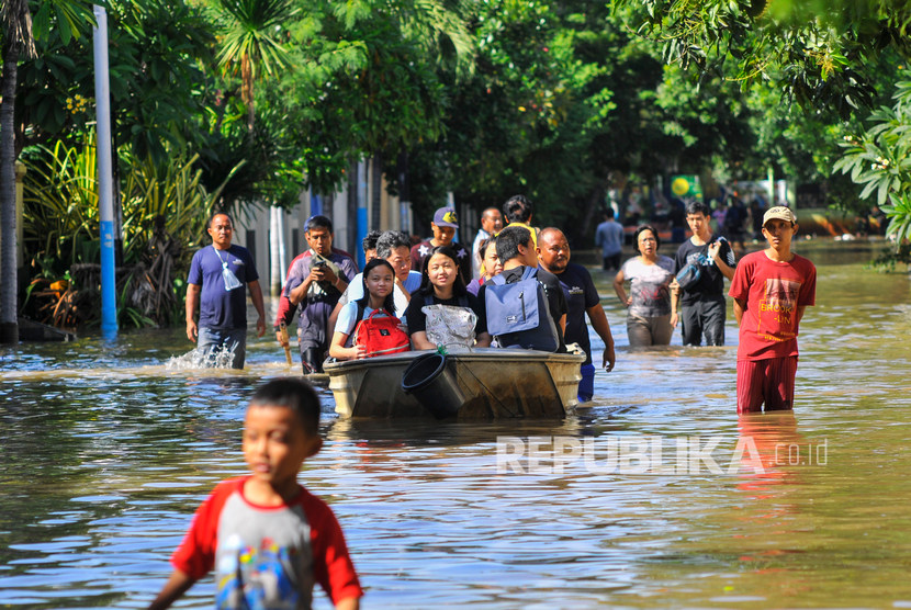 Sejumlah warga menaiki perahu saat banjir di Pulomas, Jakarta Timur.