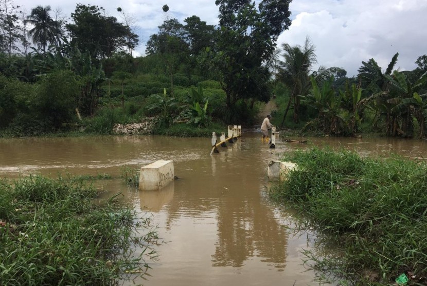 Jembatan penghubung permukiman terendam luapan Kali Cisadane. Seorang bocah perempuan dilaporkan hanyut di Kali Cisadane, Bogor.