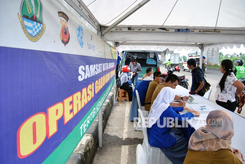 Sejumlah warga yang terkena razia, membayar pajak saat operasi Pajak Kendaraan Bermotor (PKB) di jalan KH Sholeh Iskandar, Kota Bogor, Jawa Barat, Senin (24/2/2020).