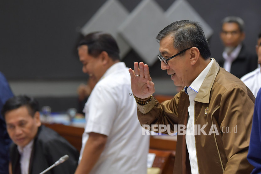 Menteri Hukum dan HAM Yasonna Laoly (kanan) melambaikan tangan saat akan mengikuti rapat kerja dengan Komisi III DPR di Kompleks Parlemen, Senayan, Jakarta, Senin (24/2/2020).