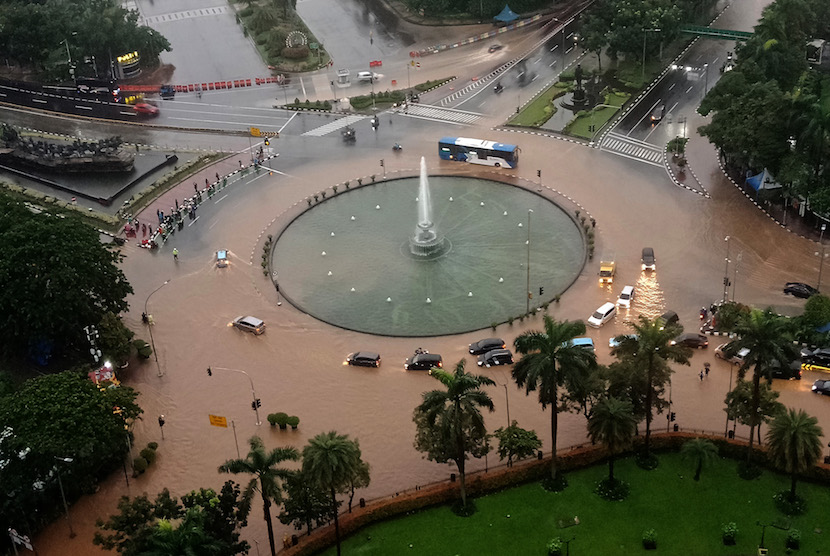 Suasana sejumlah kendaraan melintasi banjir yang menggenangi kawasan Bundaran Bank Indonesia di Jakarta Pusat, Selasa (25/2/2020) pagi. 