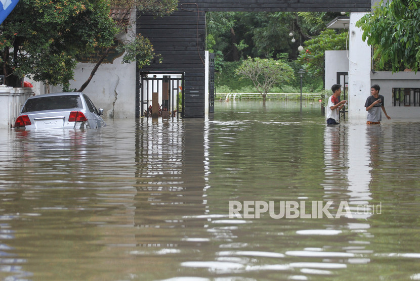 Sudin Kebakaran Jaktim Sedot Air Genangan di Tujuh Lokasi. Warga melintas didepan rumah saat banjir di kawasan Kampung Makasar, Jakarta Timur. Foto ilustrasi. 