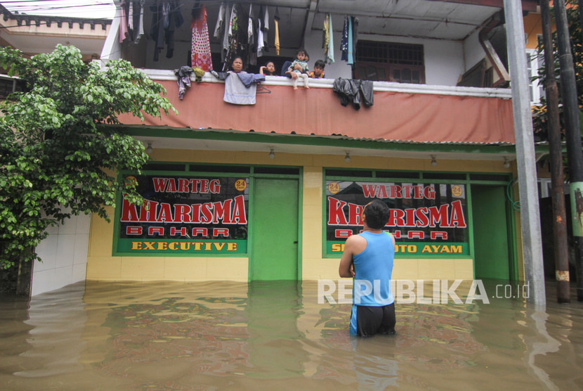 Sejumlah warga mengungsi di lantai dua rumahnya saat banjir di kawasan Kampung Makasar, Jakarta Timur, Selasa (25/2/2020). 