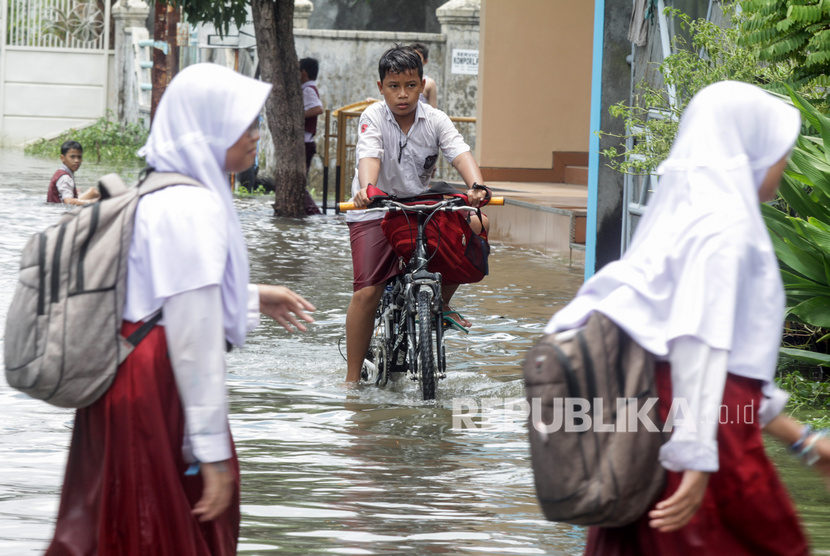 Siswa menerobos banjir yang merendam kawasan Sidokare, Sidoarjo, Jawa Timur