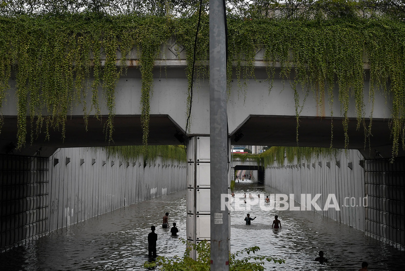 Anak-anak bermain air di underpass Jalan Angkasa yang terendam banjir, Kemayoran, Jakarta Pusat, Selasa (25/2/2020). 