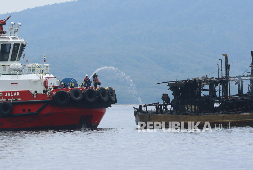Kapal tunda  melakukan pemadaman kapal ikan yang terbakar (ilustrasi).