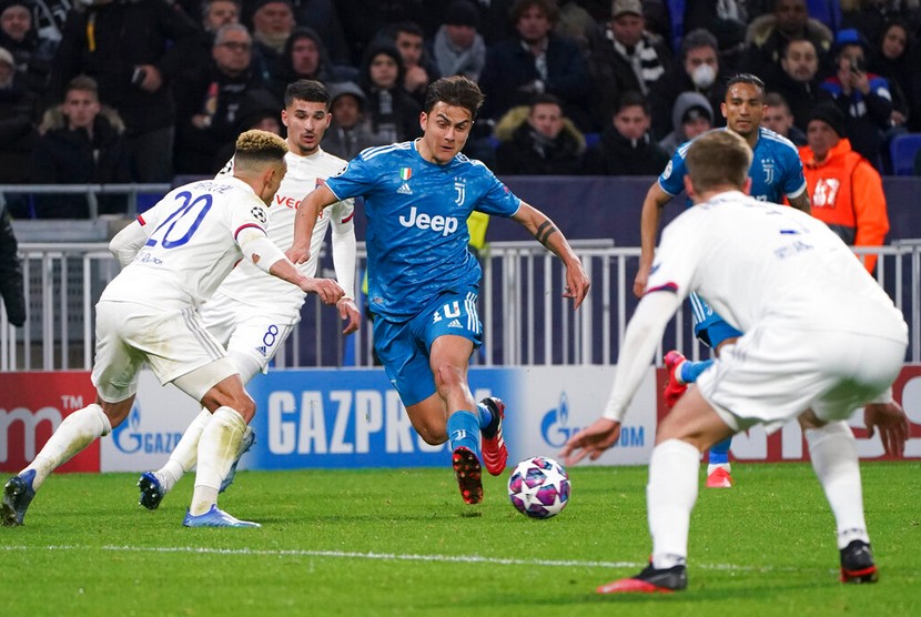  Pemain Juventus Paulo Dybala berusah melewati barisan pertahanan Lyon pada leg pertama babak 16 besar Liga Champions 2019/2020 di Stadion Groupama, Lyon, Kamis (27/2) dini hari WIB. 