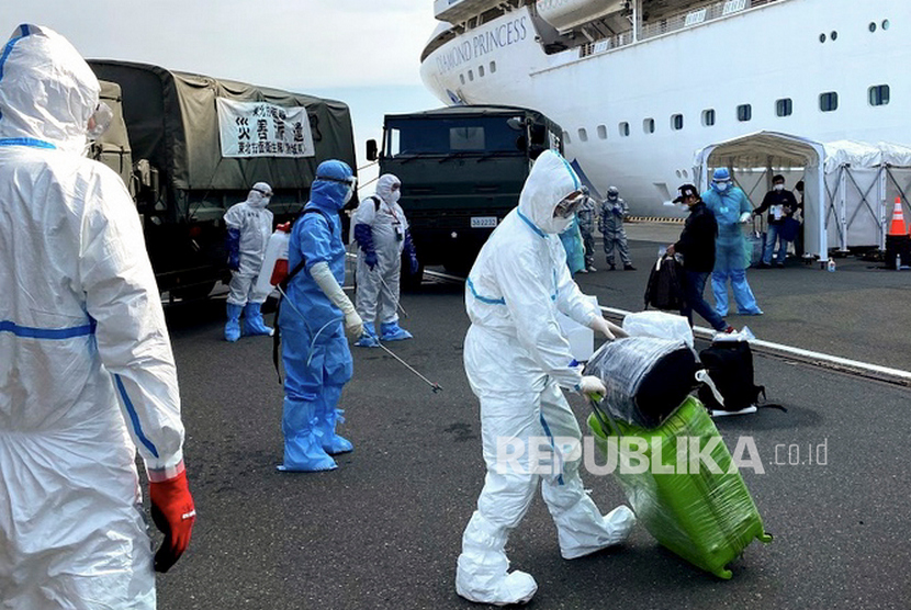 Petugas kesehatan bersiap menyemprotkan cairan disinfektan kepada WNI ABK Diamond Princess dan barang bawaan saat turun dari kapal di Yokohama, Jepang, Ahad (2/3/3030). 