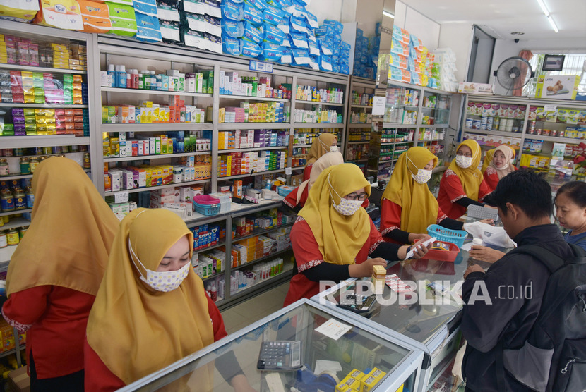 Pegawai apotek mengenakan masker saat melayani konsumen. Harga masker di beberapa kabupaten/kota di Maluku Utara naik karena diborong warga. Ilustrasi.