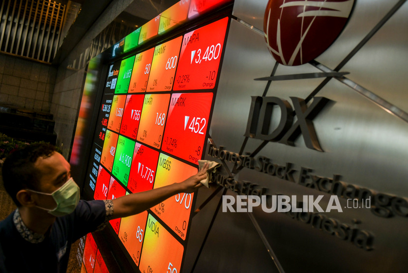 BEI Siapkan Mekanisme Pembekuan Sementara Perdagangan. Karyawan melintas di dekat layar pergerakan saham di gedung Bursa Efek Indonesia, Jakarta.