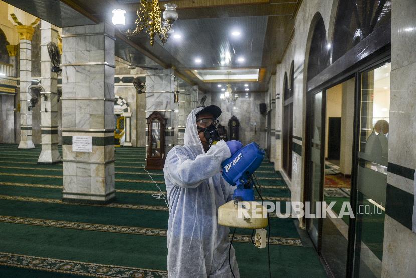 Petugas menyemprotkan disinfektan saat peluncuran Gerakan Semprot Disinfektan 10.000 Masjid di Masjid Al Munawar, Pancoran, Jakarta, Jumat (13/3). (Republika/Putra M. Akbar)