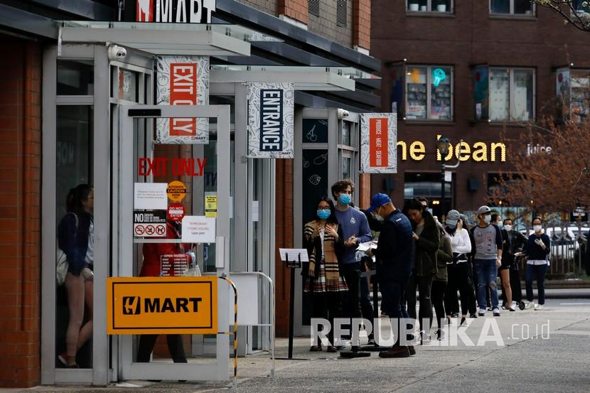 Sejumlah warga berbaris untuk memasuki toko di St. Mark’s Place, New York, Amerika Serikat, Sabtu (4/4). Inflasi tahunan AS naik pada laju paling lambat dalam lebih dari dua tahun pada bulan Juni. 