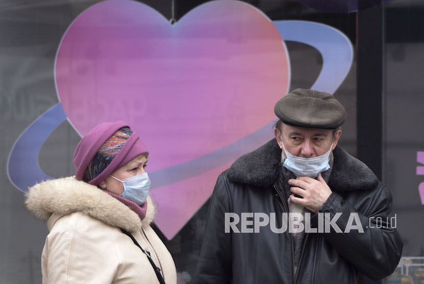 Sejumlah warga memakai masker saat menunggu di halte bus di St.Petersburg, Rusia, Senin, (6/4). 