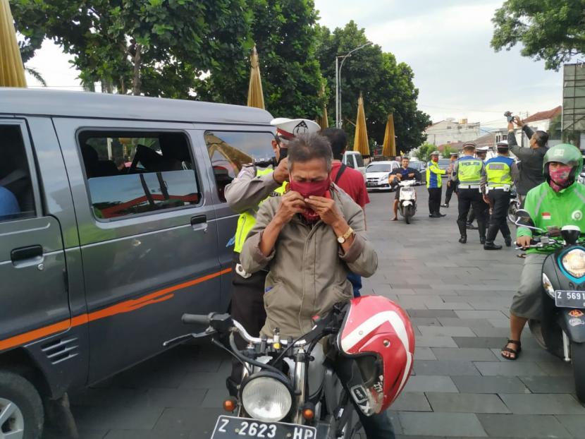 Polisi memberikan edukasi dan sosialisasi terkait pentingnya penggunaan masker di luar rumah, di Taman Kota Tasikmalaya, Jumat (10/4). Mulai Sabtu (11/4), kawasan pusat Kota Tasikmalaya akan dijadikan kawasan wajib masker dan jaga jarak (physical distancing). 