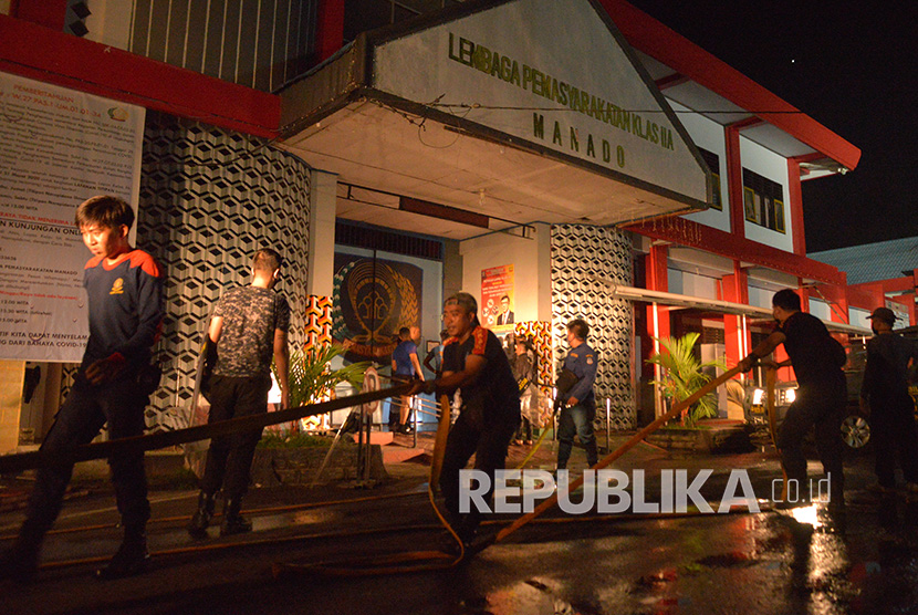 Anggota pemadam kebakaran berupaya memadamkan api yang membakar sejumlah ruangan saat terjadinya kerusuhan di Lembaga Pemasyarakatan (Lapas) Kelas IIA Manado, Tuminting, Manado, Sulawesi Utara, Sabtu (11/4/2020).