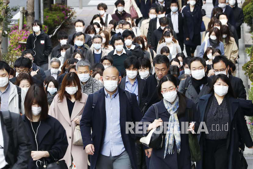Sejumlah orang berjalan memakai masker di jalan di Sendai, Tokyo Utara, Jumat (17/4). 