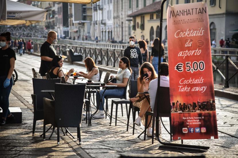Sejumlah orang menikmati makanan di sebuah restoran di distrik Trastevere selama fase dua masa pemulihan pandemi Covid-19, Roma, Italia, Senin (18/5). Italia secara bertahap mencabut kebijakan lockdown yang diterapkan untuk membendung penyebaran COVID-19. 
