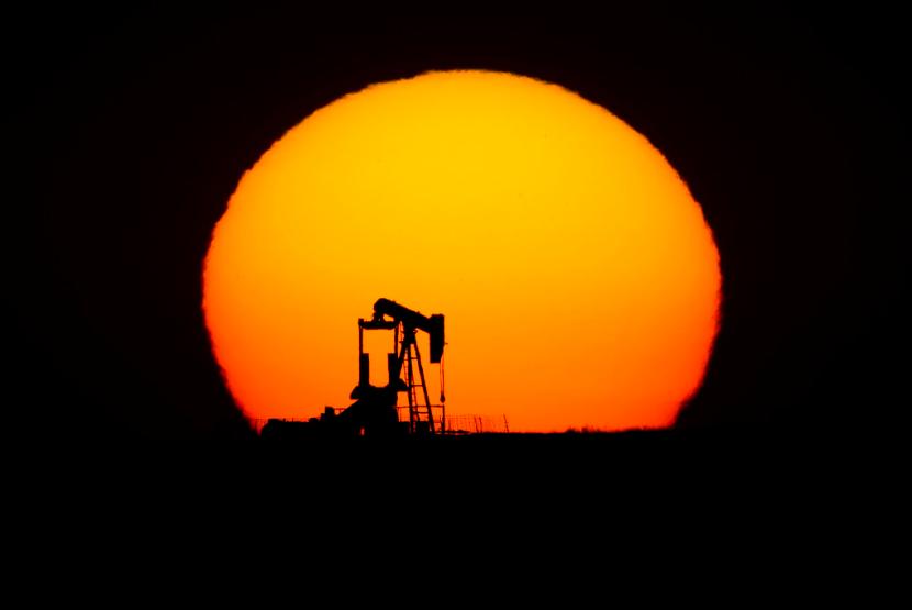 Siluet kilang minyak di Oakley, Kansas, Amerika Serikat. Harga minyak naik tipis pada akhir perdagangan Rabu (23/9), didukung data pemerintah AS yang menunjukkan persediaan minyak mentah dan bahan bakar turun pekan lalu.