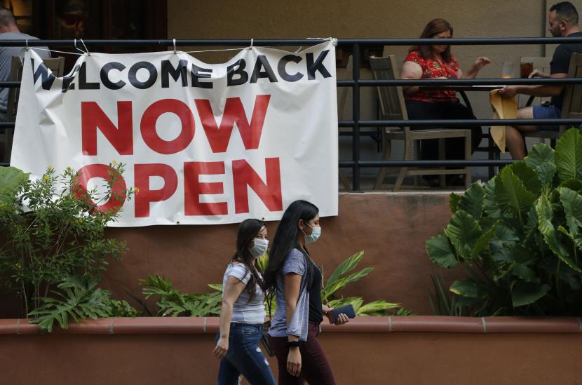 Pengunjung melewati sebuah restoran yang telah dibuka kembali di River Walk di San Antonio, Texas, Rabu (27/5). Texas dibuka kembali oleh warga setelah karantina pandemi virus corona covid19. Foto AP / Eric Gay