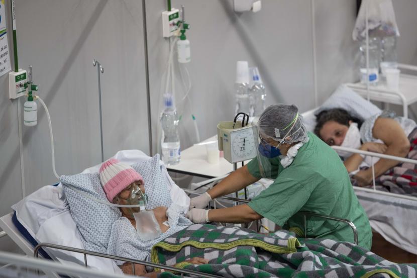 Pasien Covid-19 berbaring di ranjang di rumah sakit lapangan yang dibangun di dalam gym di Santo Andre, di Sao Paulo, Brasil, Selasa (9/6). Hoaks mengenai Covid-19 terus beredar menjelang era Normal Baru.