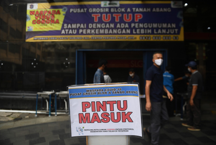 Sejumlah pekerja memasang tanda arah masuk pengunjung saat simulasi persiapan pembukaan Pasar Tanah Abang di Jakarta, Kamis (11/6/2020).  