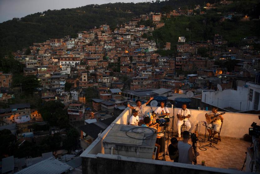 Anggota band Tempero de Croila bermain musik di atap rumah mereka di Rio de Janeiro, Brasil, Jumat (19/6). Jumlah kasus baru Covid-19 di Brazil pada Jumat melewati satu juta dengan korban meninggal mendekati 50.000 jiwa.