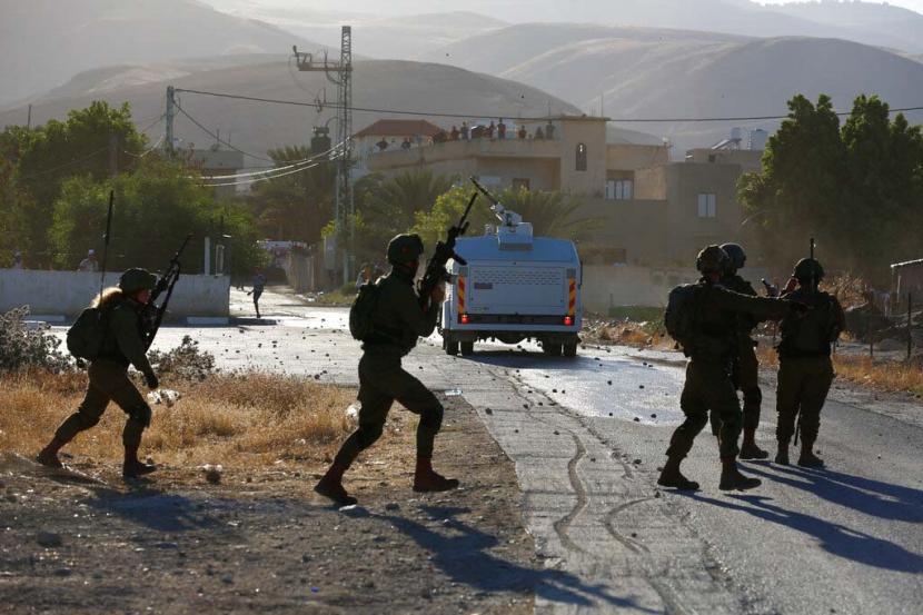 Pasukan Israel berbentrokan dengan demonstran Palestina selama protes terhadap rencana Israel untuk mencaplok bagian-bagian dari Tepi Barat dan inisiatif Timur Tengah Trump, di desa Fasayil, di Lembah Jordan, Rabu, 24 Juni 2020. 