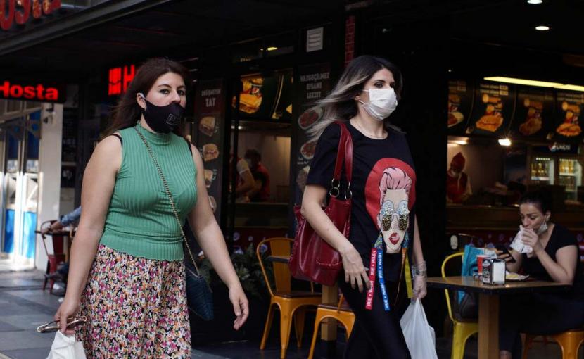 Warga mengenakan masker saat beraktivitas di pusat kota, di Ankara, Turki. Ekonomi Turki tumbuh positif di tengah pandemi covid 19.