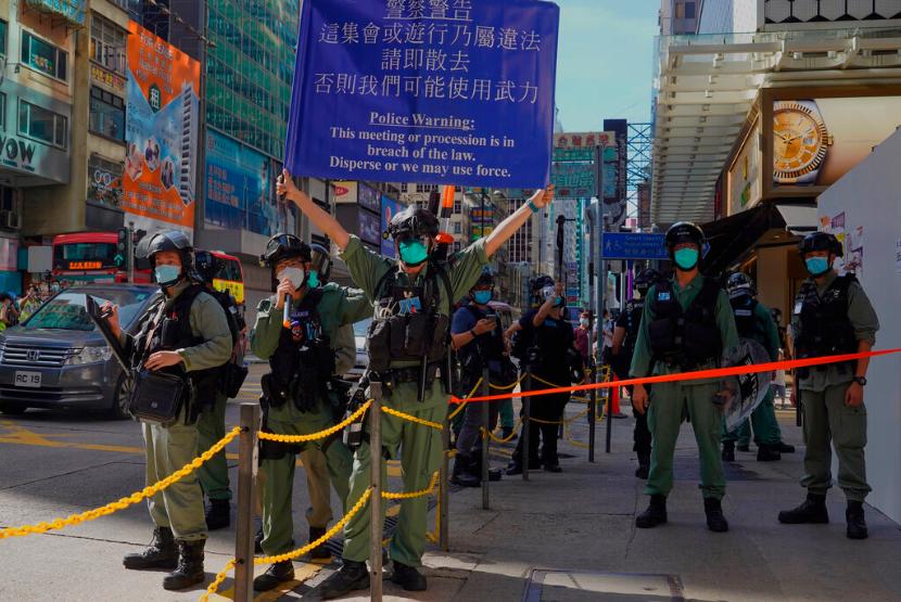 Polisi Hong Kong berjaga di tengah aksi unjuk rasa melawan UU Keamanan Nasional di Hong Kong, Ahad (28/6).