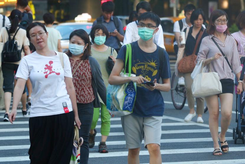 Warga menyeberang di jalanan Taipei, Taiwan, di tengah pandemi Covid-19. Taiwan telah menyetujui penggunaan dexamethasone untuk pasien Covid-19 di tengah kelangkaan remdesivir.