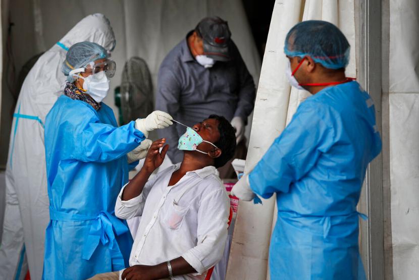 Petugas medis mengambil sampel lendir di hidung seorang warga di New Delhi, India, Selasa (18/8). Kementerian Kesehatan India mendata pada hari Sabtu (24/10) ada laporan 650 kematian baru akibat Covid-19.
