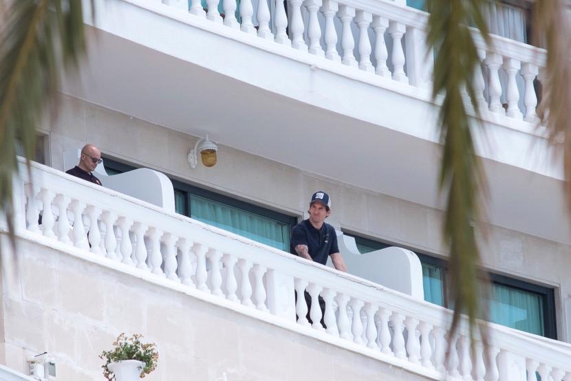  Penyerang FC Barcelona asal Argentina, Lionel Messi (tengah), terlihat di balkon kamarnya di Nixe Palace Hotel, di Palma de Mallorca, Pulau Majorca, Spanyol, belum lama ini.