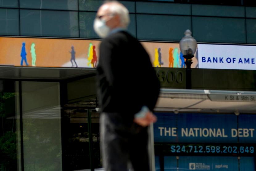Seorang warga berdiri di depan papan reklame di K Street Washington, Amerika Serikat, baru-baru ini. Defisit anggaran AS pada paruh pertama tahun fiskal 2021 mencapai 1,7 triliun dolar AS.