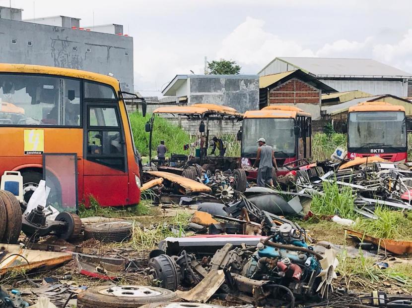 Sejumlah pekerja tengah membongkar atau membelah ratusan ‘bangkai’ bus TransJakarta. Ilustrasi