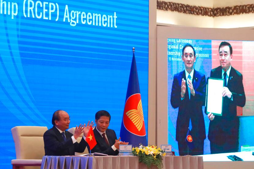 Perdana Menteri Vietnam Nguyen Xuan Phuc (kiri) dan Menteri Perdagangan Tran Tuan Anh bertepuk tangan usai melakukan penandatanganan pakta kerja sama Regional Comprehensive Economic Partnership (RCEP), Ahad (15/11). Sepuluh negara ASEAN ditambah lima negara Asia lain seperti China dan Jepang sepakat untuk membentuk blok perdagangan terbesar di dunia.