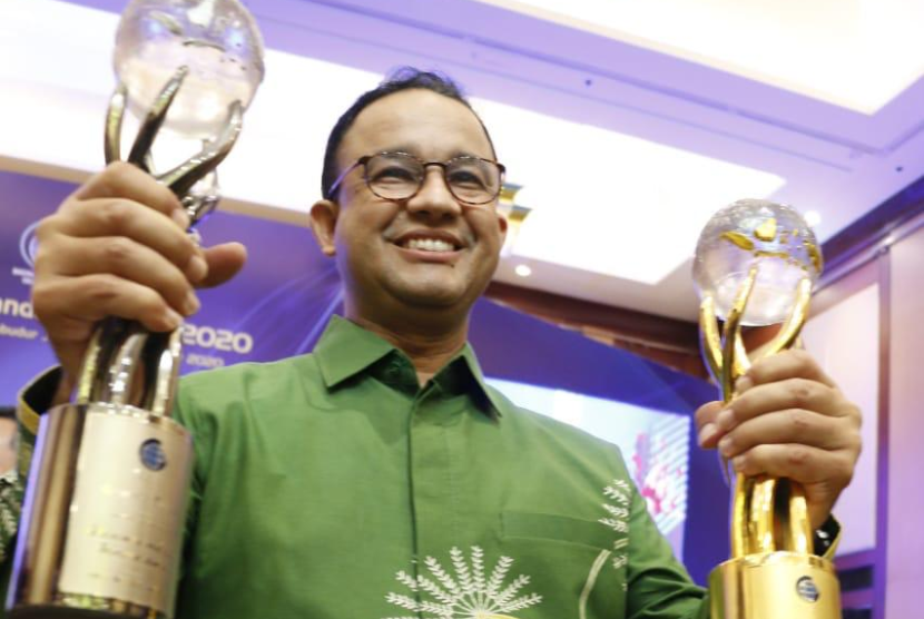 Gubernur DKI Jakarta, Anies Rasyid Baswedan menunjukkan piala atas prestasi yang diterima Pemprov DKI.