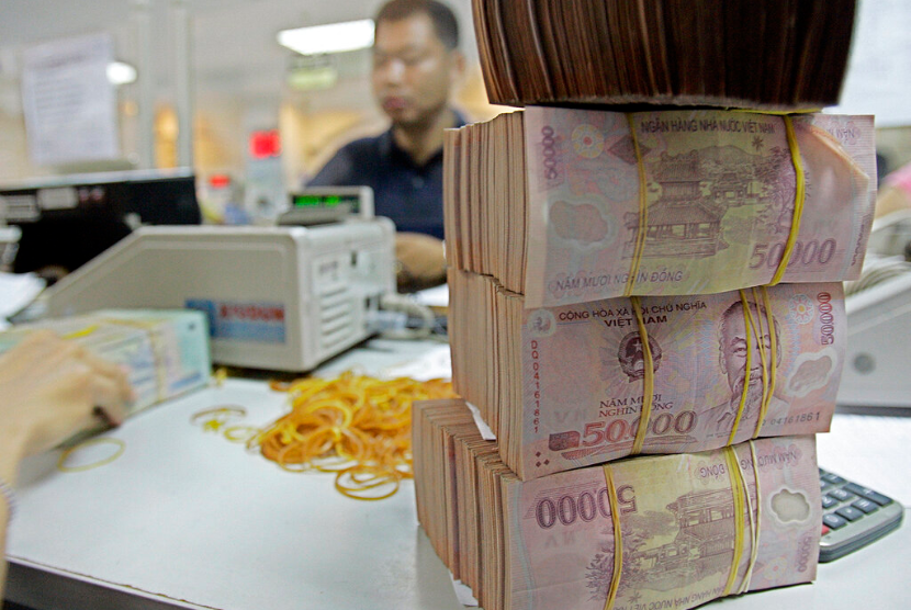 Petugas tengah menghitung uang dong Vietnam di sebuah bank di Hanoi, Vietnam.