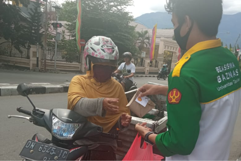 Peserta Beasiswa Cendekia Baznas di Universitas Tadulako mengadakan aksi sosial dengan berbagi 100 nasi bungkus kepada masyarakat.