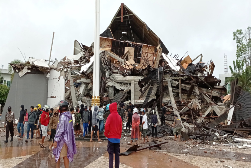 Warga mengamati Kantor Gubernur Sulawesi Barat yang rusak akibat gempa bumi, di Mamuju, Sulawesi Barat, Jumat (15/1).