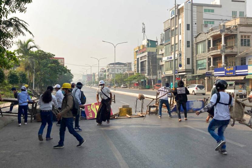 Demonstran menutup jalan utama di Mandalay, Myanmar, Ahad (28/2).  Otoritas militer Myanmar telah mengeksekusi empat aktivis demokrasi yang dituduh membantu melakukan aksi teror. 