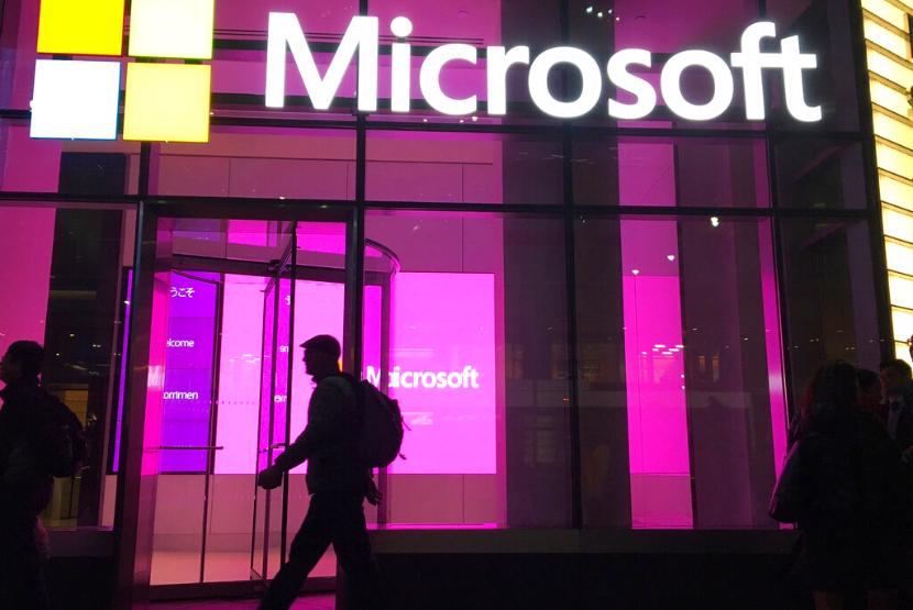 Pejalan kaki melintasi kantor Microsoft di New York. Microsoft, dikabarkan melakukan pemutusan hubungan kerja (PHK). Ilustrasi.
