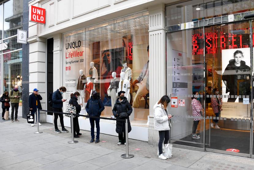 Warga mengantre masuk toko di Oxford Street di London, Inggris, Senin (12/4).
