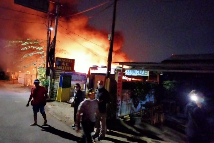Sejumlah petugas sedang berupaya memadamkan api yang membakar sebuah gudang mebel di Jalan Pulo Gebang, Cakung, Jakarta Timur, Senin (19/4) malam. 